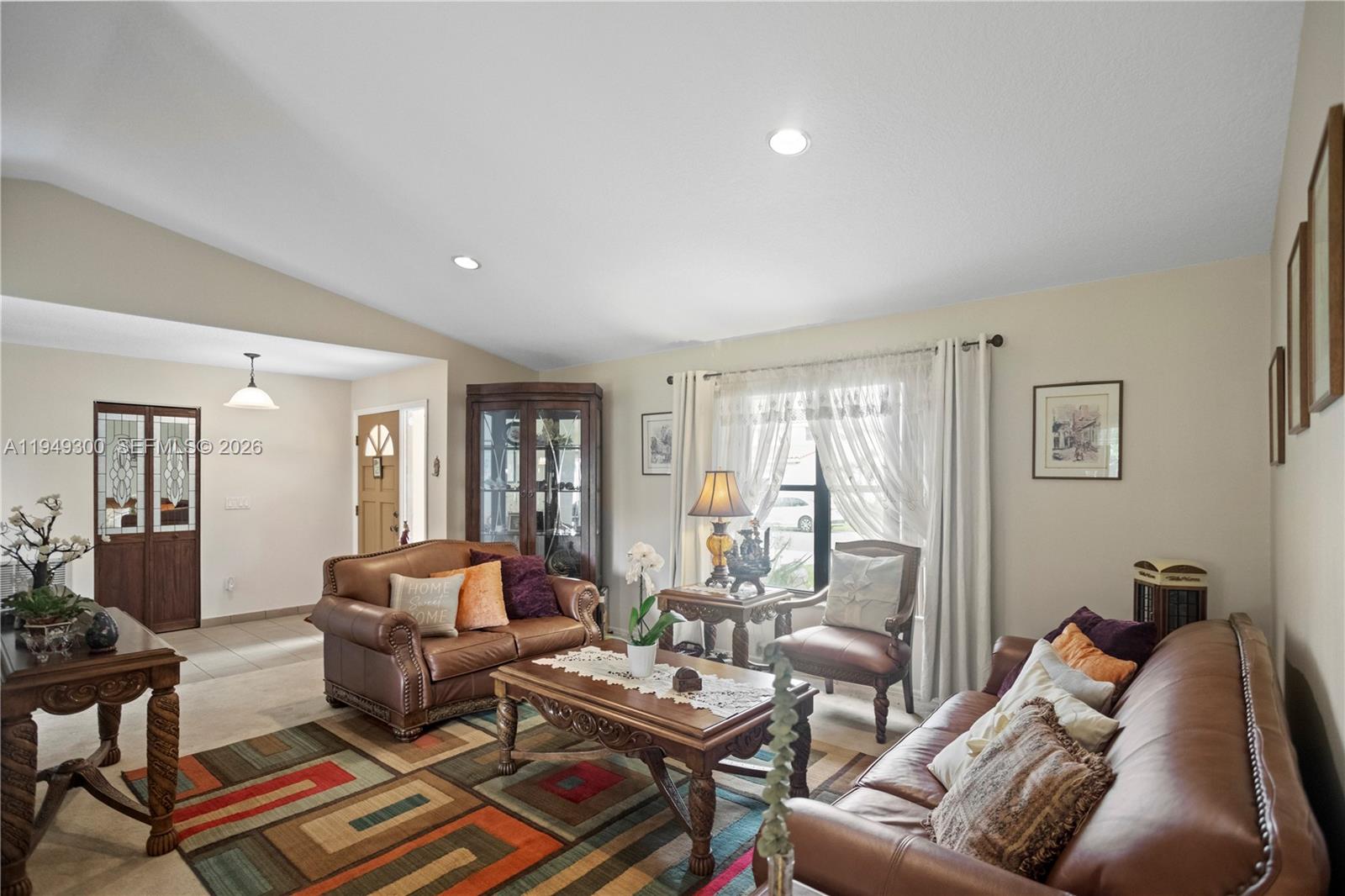 A living room features leather sofas, a patterned area rug, and a wooden coffee table — 15824 Cotswold Ct, Davie FL 33331, DAVIE, FL