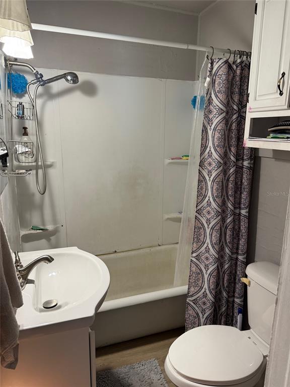 A bathroom features a white pedestal sink, a toilet, and a shower-tub combination — 1222 GOLCONDA ROAD, LAKELAND, FL