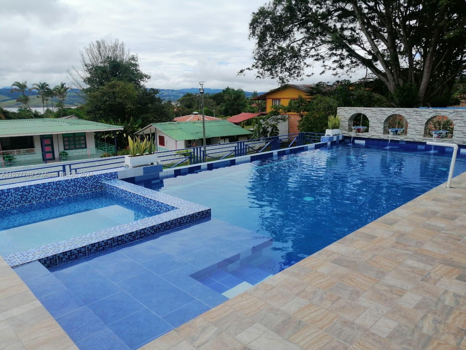 An outdoor swimming pool with a tiled deck and a small attached spa area — Darien Lago Calima El Darien, 00000, FL