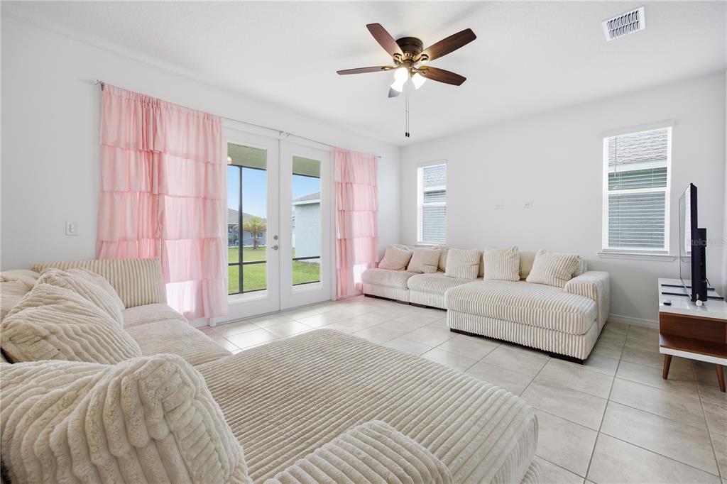 A living room features two large beige sectionals, tile flooring, and pink curtains — 7238 SW 60TH LANE, OCALA, FL