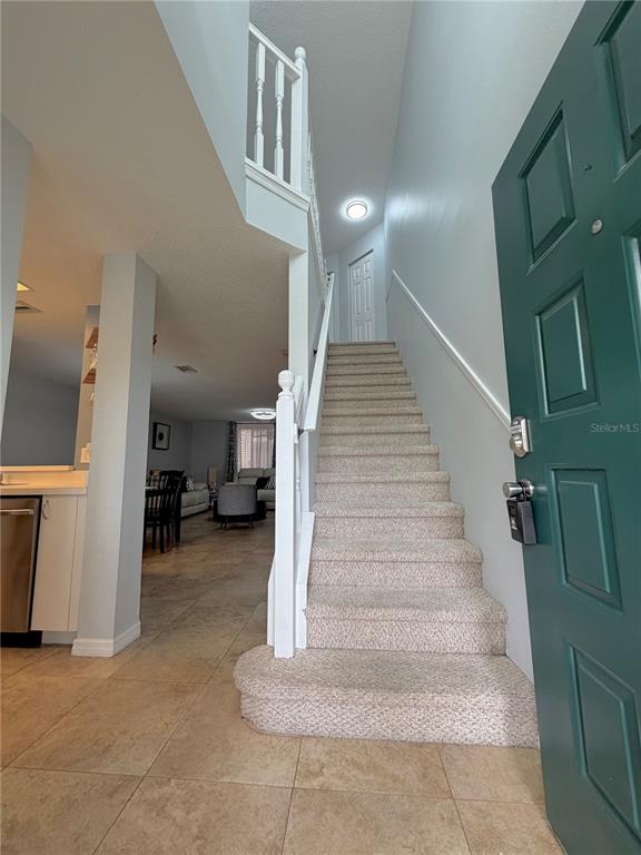 An entryway features a carpeted staircase, tile flooring, and a green front door — 2122 CLOVER HILL ROAD, PALM HARBOR, FL