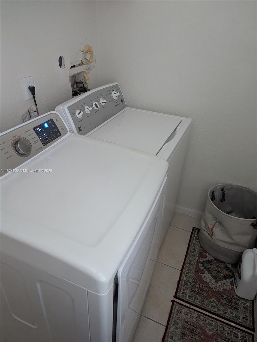 A laundry room features a white top-load washer and dryer with exposed wall plumbing — 8496 SW 29th St # 104, Miramar FL 33025, MIRAMAR, FL