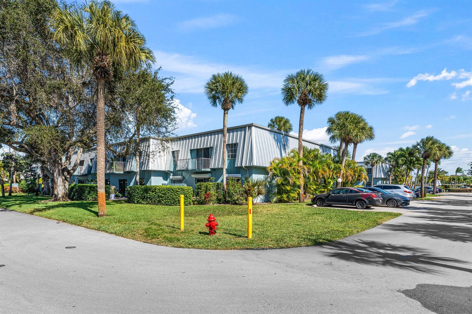 A two-story apartment building with a metal roof surrounded by palm trees and landscaping — 950 S Kanner Highway # 10, Stuart FL 34994, STUART, FL