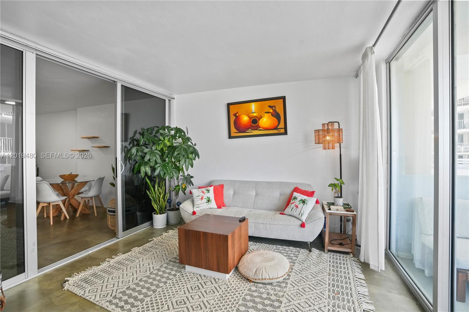 A living room features a light gray sofa, a wooden cube coffee table, and a rug — 1200 West Ave # 819, Miami Beach FL 33139, MIAMI BEACH, FL