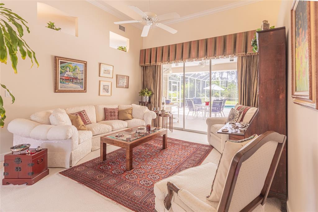 A living room features a white sofa, patterned area rug, and sliding glass doors to a patio — 39 WELLSTREAM LANE, PALM COAST, FL