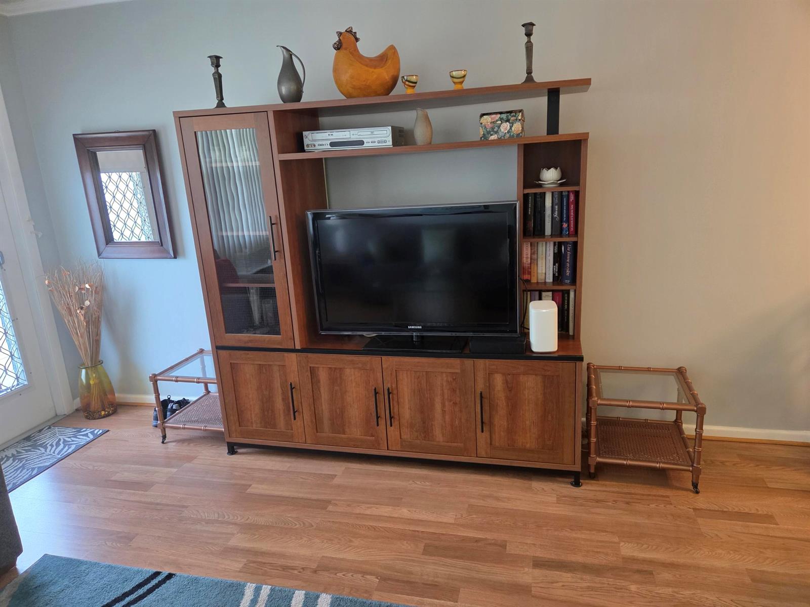 A living room features a large wooden entertainment center with a television and glass-front cabinet — 138 Newport I, Deerfield Beach FL 33442, DEERFIELD BEACH, FL