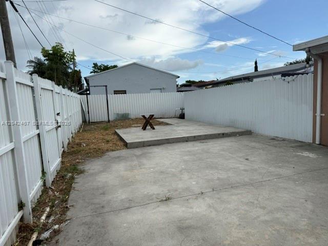 A concrete patio area is enclosed by a white vinyl fence in a backyard — 397 W 57th St # 3, Hialeah FL 33012, HIALEAH, FL