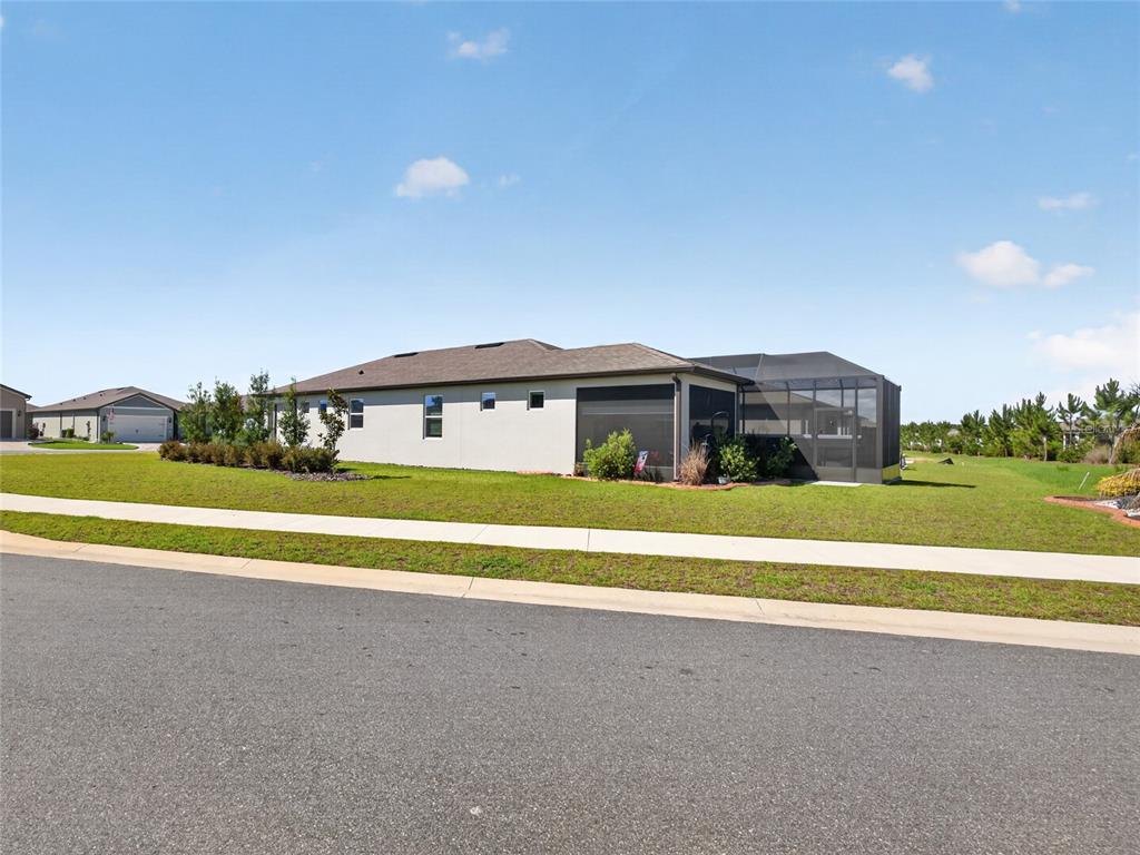 A single-story house with a screened-in lanai sits on a grassy lot near a street — 5798 SW 86TH AVENUE ROAD, OCALA, FL