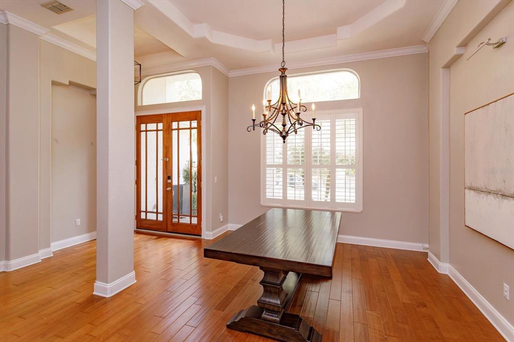 A dining room features a dark wood table, a chandelier, and hardwood floors — 8816 GREAT COVE DRIVE, ORLANDO, FL
