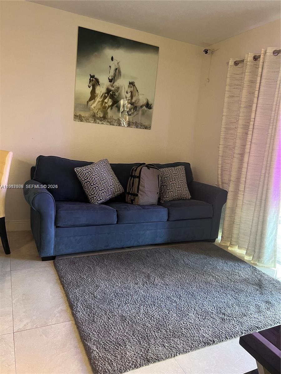 A blue sofa sits on a gray rug in a room with a horse painting — 5201 NW 7th St # 314, Miami FL 33126, MIAMI, FL