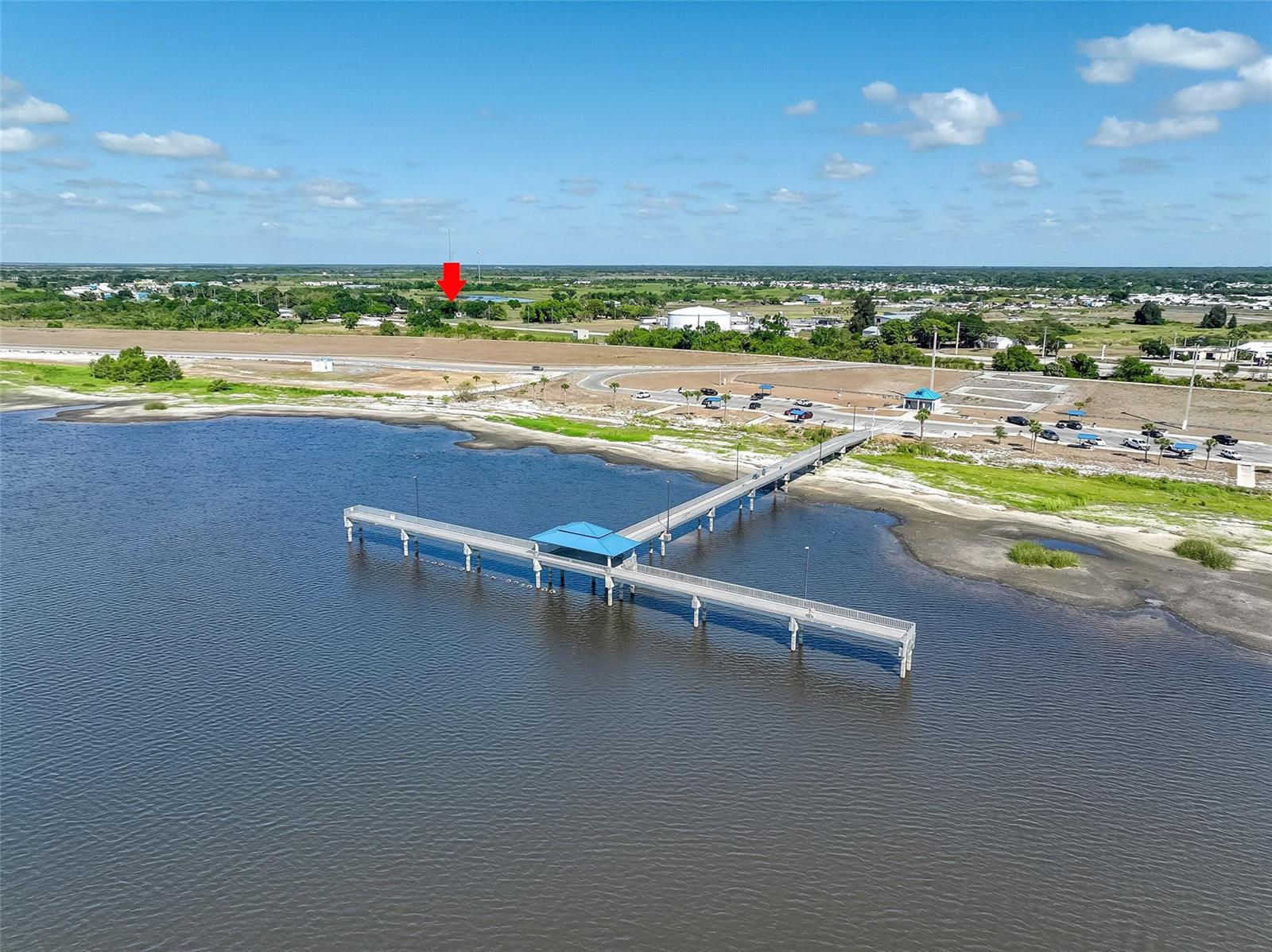 An aerial view shows a long fishing pier extending into a lake near a parking lot — 651 State Road 78, Okeechobee FL 34974, OKEECHOBEE, FL