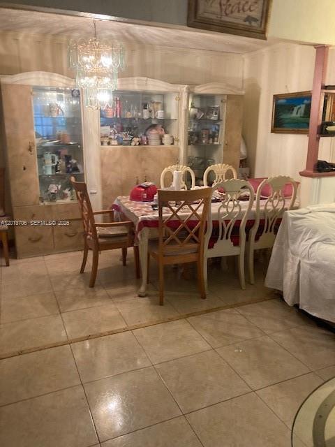 A dining room features a wooden table with chairs, a large china cabinet, and tile flooring — 321 NW 145th St, Miami FL 33168, MIAMI, FL