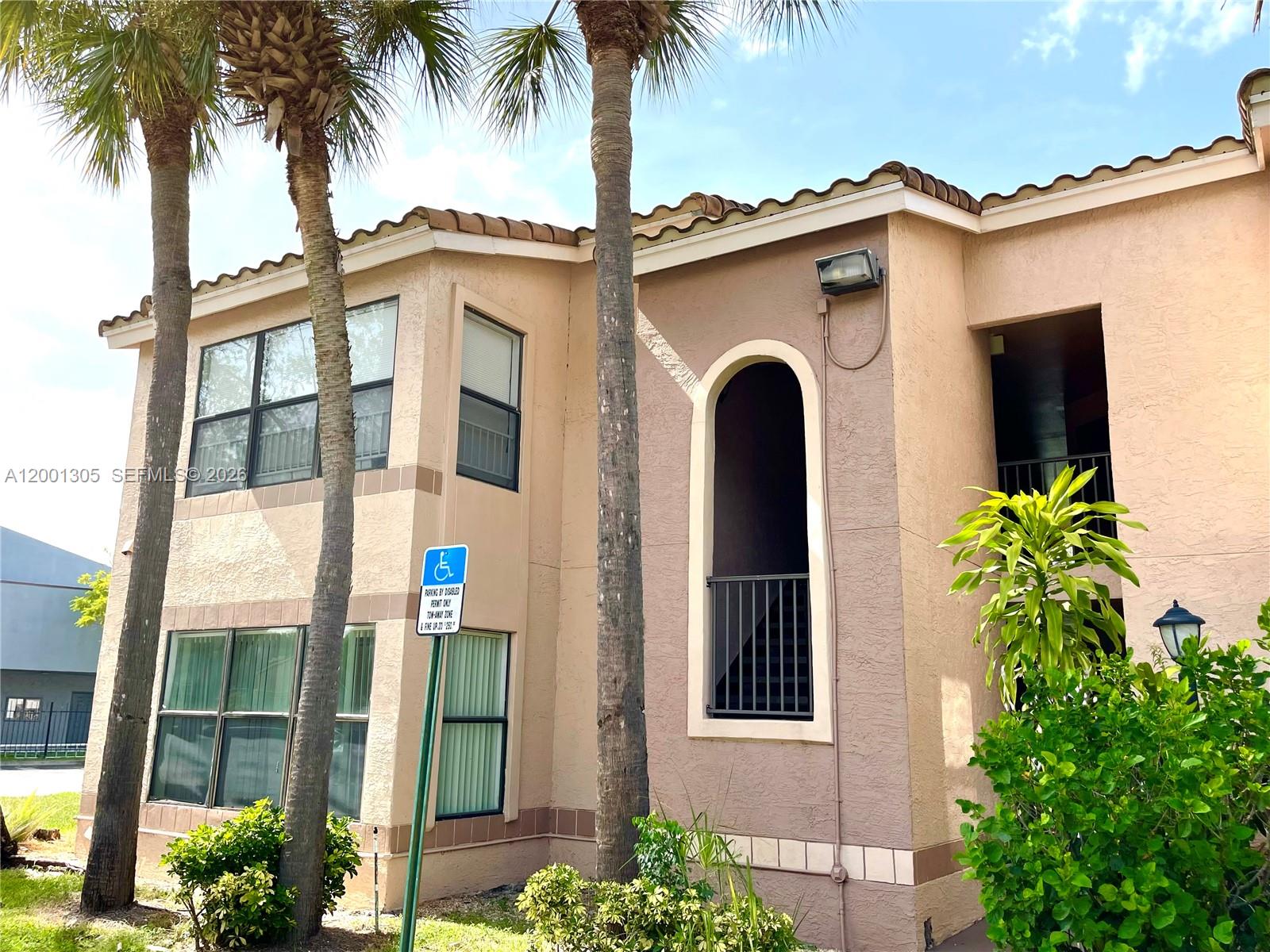 A two-story stucco apartment building exterior features palm trees and a handicap parking sign — 2826 S University Dr # 3101, Davie FL 33328, DAVIE, FL