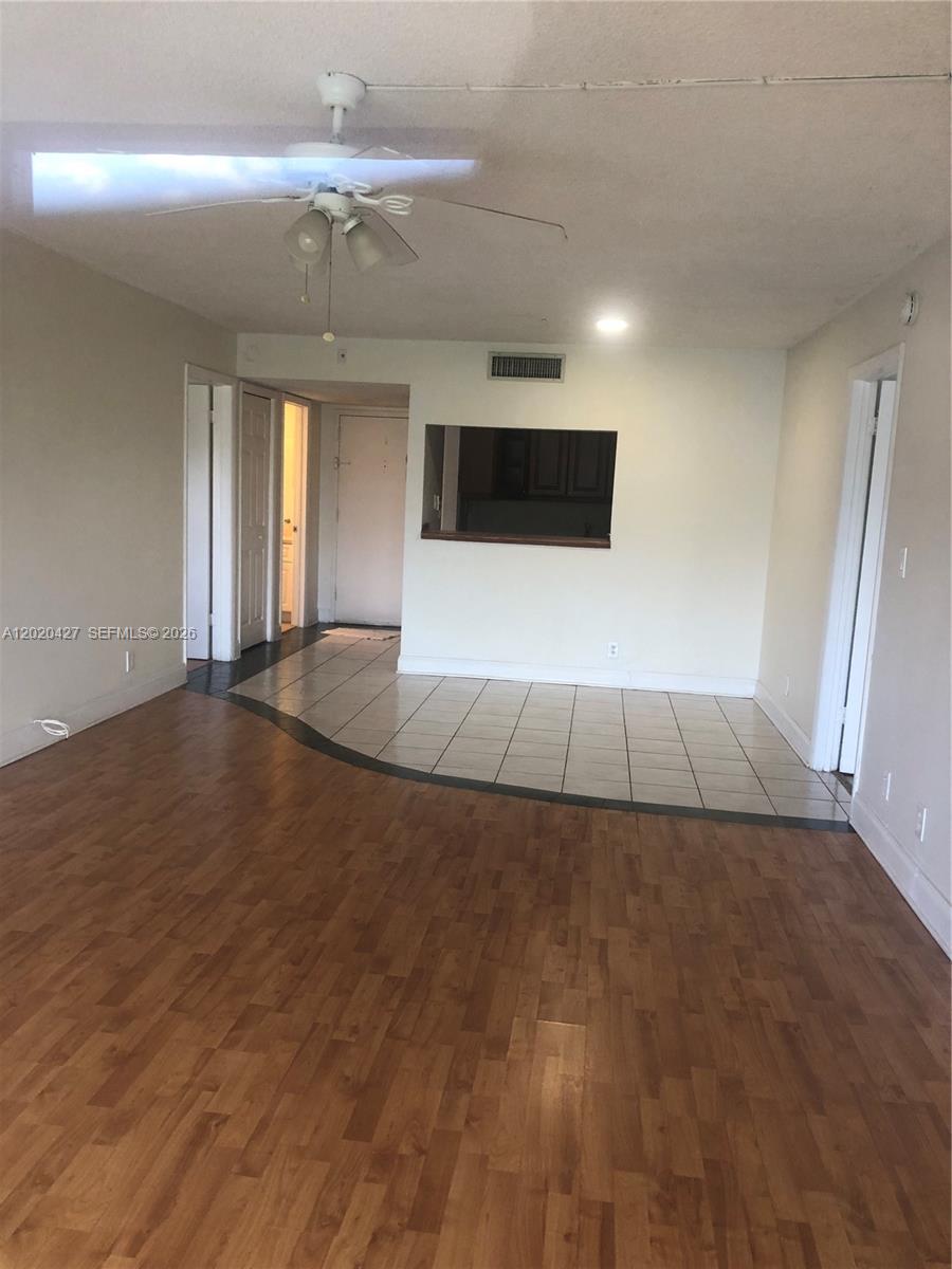 An interior view shows a living area with wood flooring, tiled entryway, and a ceiling fan — 210 Lakeview Dr # 207, Weston FL 33326, WESTON, FL