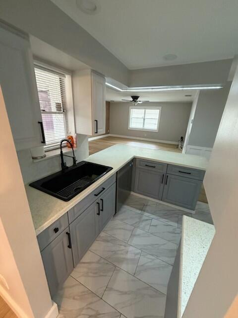 A kitchen with gray cabinets, a black sink, and white countertops overlooks a living area — 23153 SW 53rd Avenue, Boca Raton FL 33433, BOCA RATON, FL