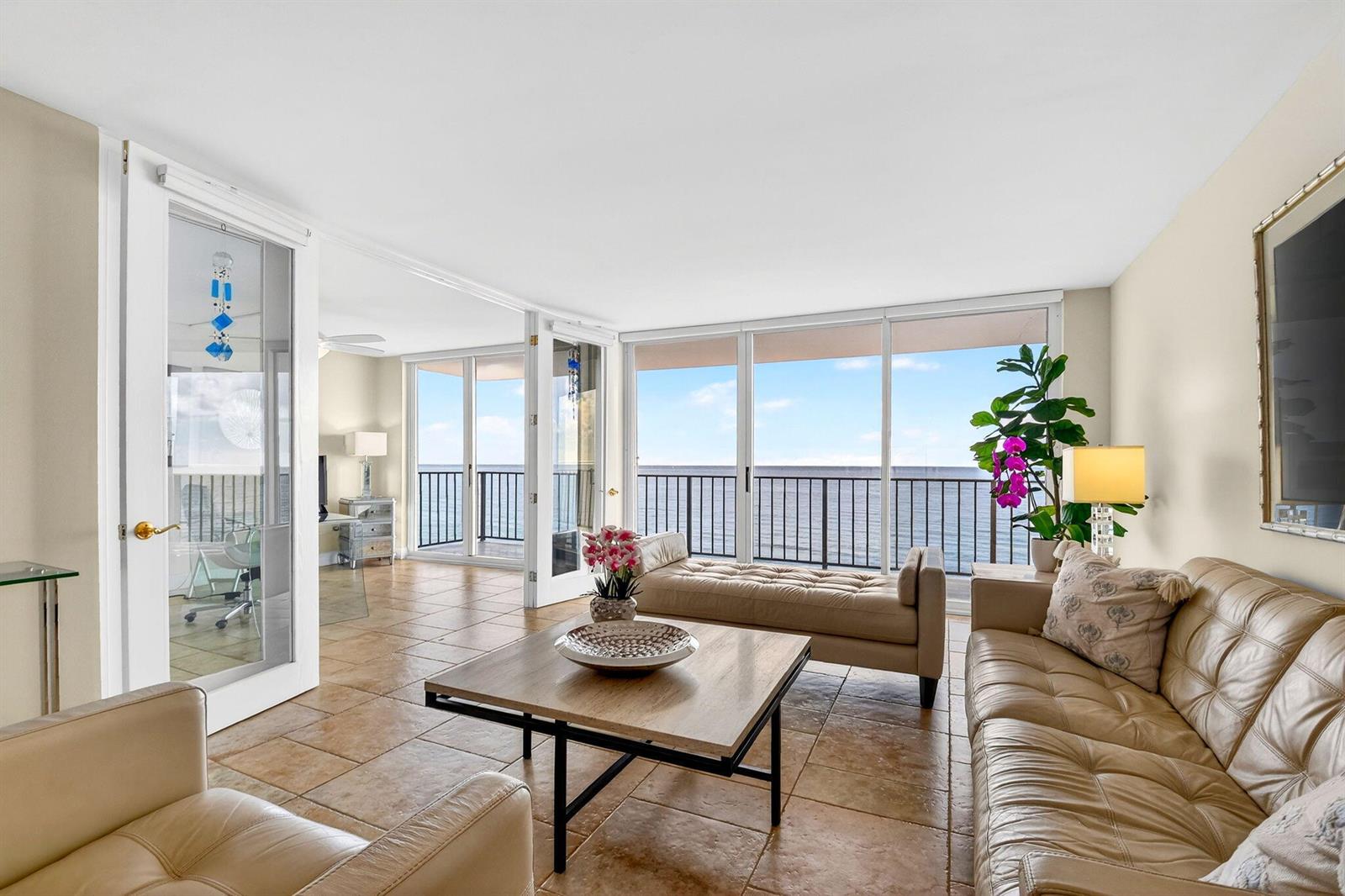 A living room with tile floors, leather furniture, and floor-to-ceiling windows overlooking the ocean — 3456 S Ocean Boulevard # 5020, Palm Beach FL 33480, PALM BEACH, FL