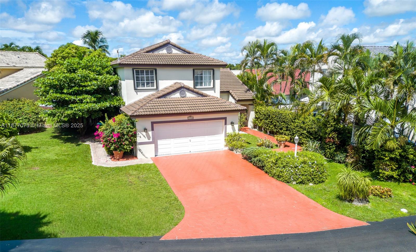 A two-story house with a tiled roof, a white garage door, and a red driveway — 15905 SW 83rd Ter, Miami FL 33193, MIAMI, FL