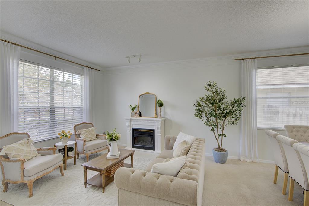 A living room features a fireplace, a tufted sofa, two armchairs, and a dining area — 963 CHERRY VALLEY WAY, ORLANDO, FL