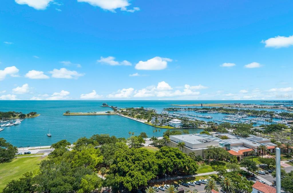 An aerial view shows a marina, a park, and a large building near the ocean — 176 4TH AVENUE NE UNIT 201, ST PETERSBURG, FL