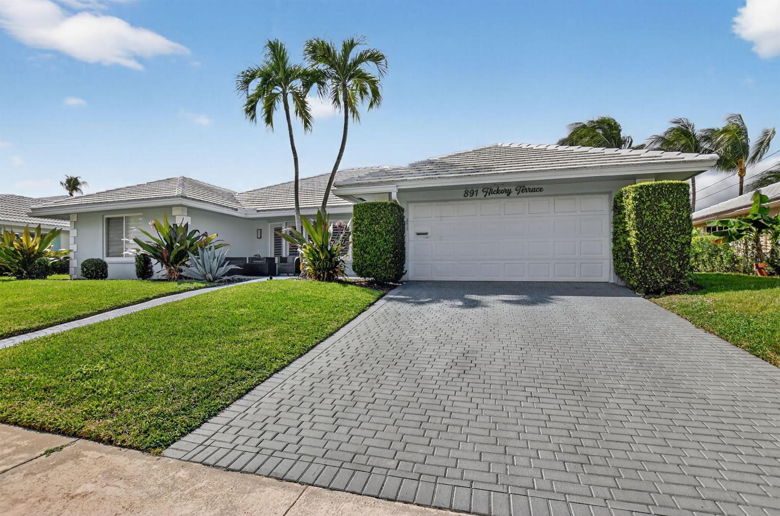 A single-story house with a gray paver driveway, white garage door, and two palm trees — 891 Hickory Terrace, Boca Raton FL 33486, BOCA RATON, FL