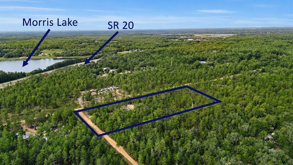 An aerial view shows a rectangular plot of land outlined in blue near a lake — 00 UNASSIGNED LOCATION, HAWTHORNE, FL