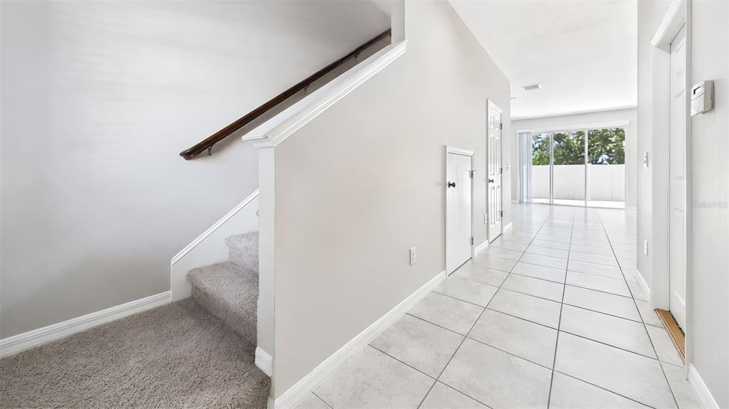 A staircase with carpeted steps leads up from a tiled hallway with white walls — 7214 GRAND ELM DRIVE, RIVERVIEW, FL