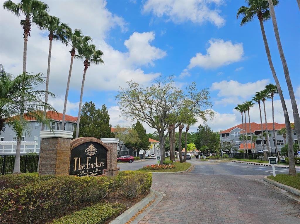 The entrance sign for The Enclave at Richmond Place features palm trees and apartment buildings — 18001 RICHMOND PLACE DRIVE UNIT 716, TAMPA, FL