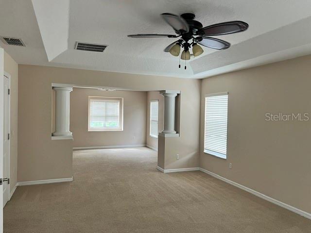 A carpeted room features a tray ceiling with a fan and two decorative columns — 739 REFLECTIONS LANE, WINTER GARDEN, FL