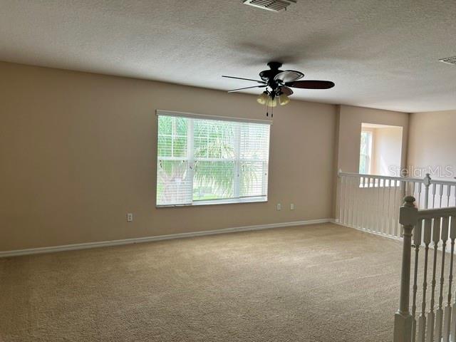 A carpeted loft area features a ceiling fan, a large window, and a white railing — 739 REFLECTIONS LANE, WINTER GARDEN, FL