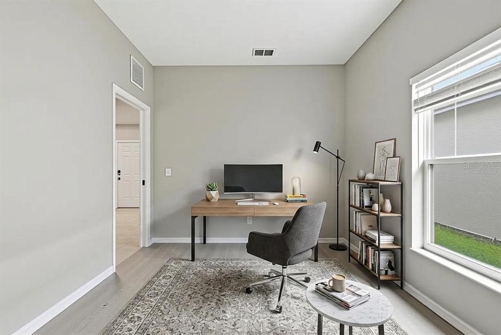 A home office features a wooden desk, a gray chair, a bookshelf, and a patterned rug — 4317 HICKORY STONE CIRCLE, ORLANDO, FL