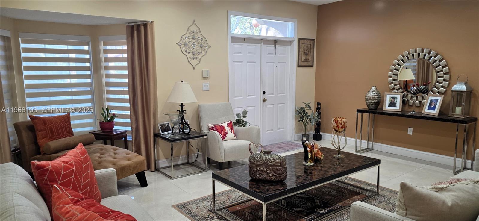 A living room features tile flooring, a coffee table, a console table, and a mirror — 5769 NW 99th Ave, Doral FL 33178, DORAL, FL