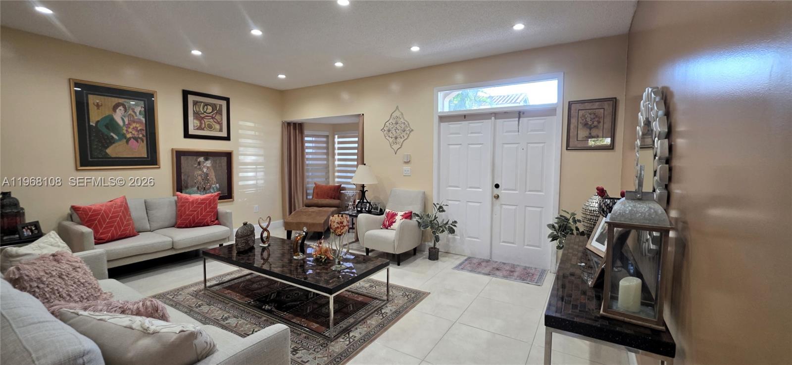 A living room features light-colored tile floors, recessed lighting, and a double-door entryway — 5769 NW 99th Ave, Doral FL 33178, DORAL, FL
