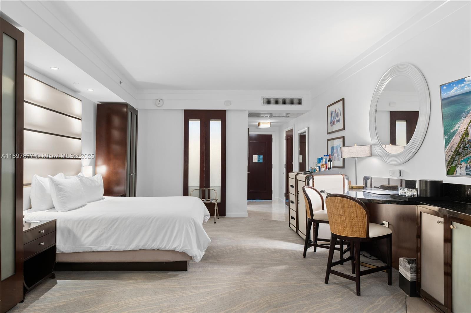 A hotel room features a bed, a desk with two chairs, and a large mirror — 4391 Collins Ave # 1403, Miami Beach FL 33140, MIAMI BEACH, FL