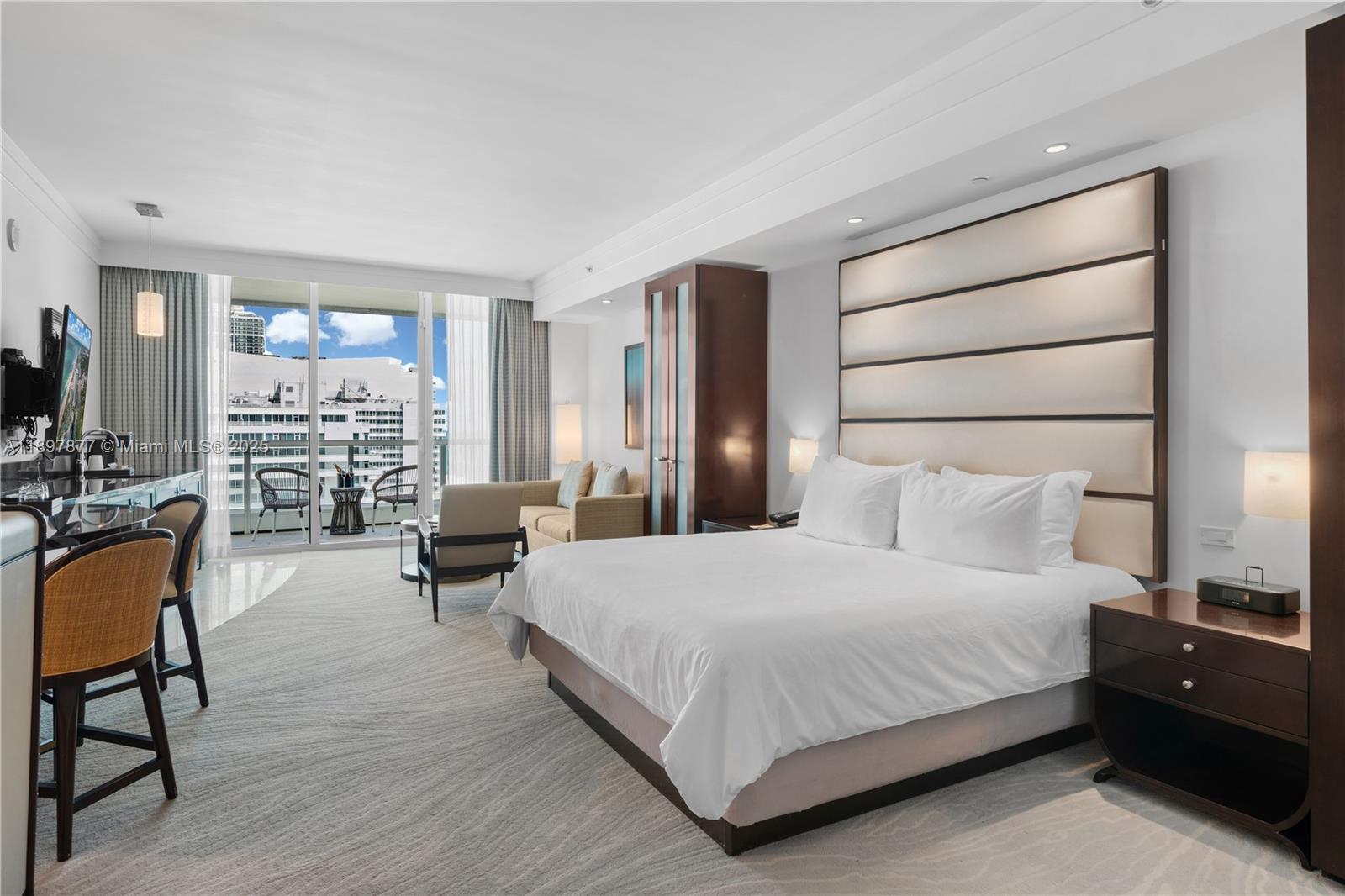 A hotel bedroom features a king bed, a seating area, and a balcony with city views — 4391 Collins Ave # 1403, Miami Beach FL 33140, MIAMI BEACH, FL