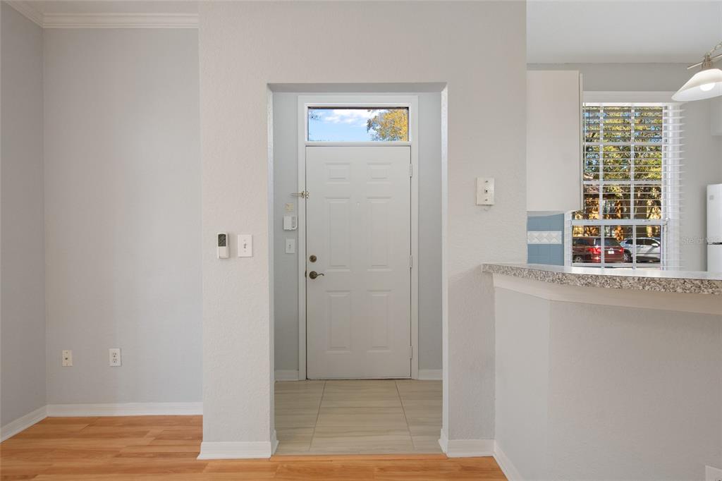 An interior view shows a white front door with a transom window and tile flooring — 6384 RALEIGH STREET UNIT 2205, ORLANDO, FL