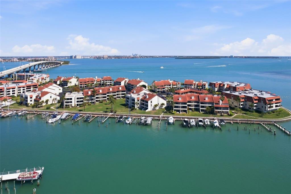 An aerial view of a waterfront condominium complex with a boat dock and bridge — 128 1ST STREET E. UNIT 102, TIERRA VERDE, FL