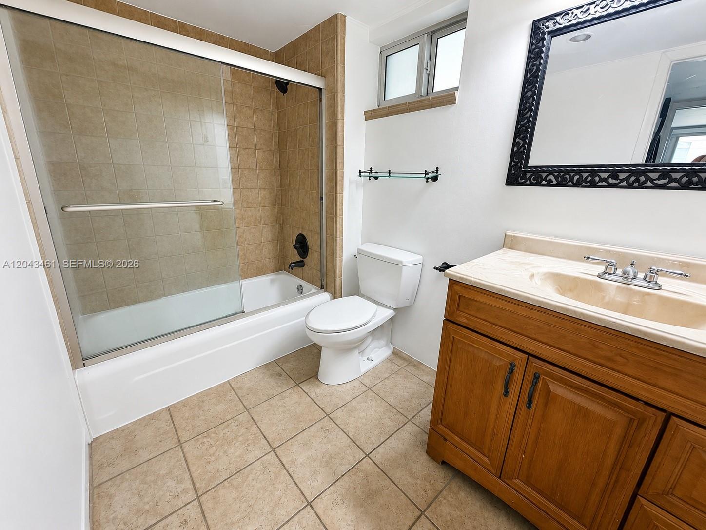 A bathroom features a tub-shower combo, a white toilet, and a wooden vanity cabinet — 1670 Bay Rd # 3D, Miami Beach FL 33139, MIAMI BEACH, FL