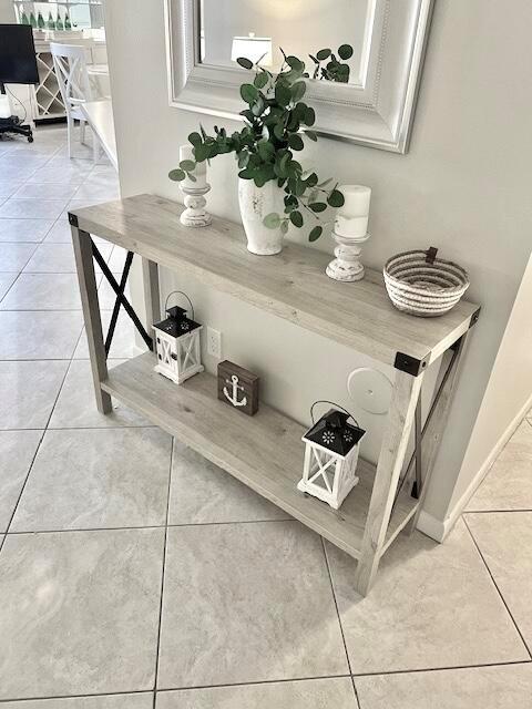 A light wood console table with black metal accents stands in a tiled entryway — 1605 S Us Highway 1 # A106, Jupiter FL 33477, JUPITER, FL