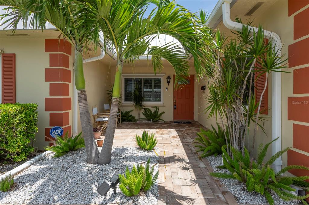 A paved walkway leads to the front entrance of a house with palm trees — 6575 GREEN VALLEY DRIVE, SEMINOLE, FL