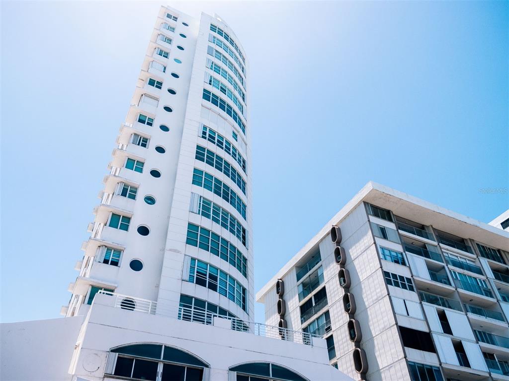 A low-angle view of two modern white high-rise buildings against a clear blue sky — Regatta 996 ASHFORD AVE UNIT 6, SAN JUAN, PR