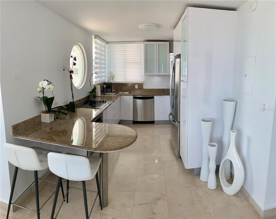 A kitchen features white cabinets, stainless steel appliances, granite countertops, and a breakfast bar — Regatta 996 ASHFORD AVE UNIT 6, SAN JUAN, PR