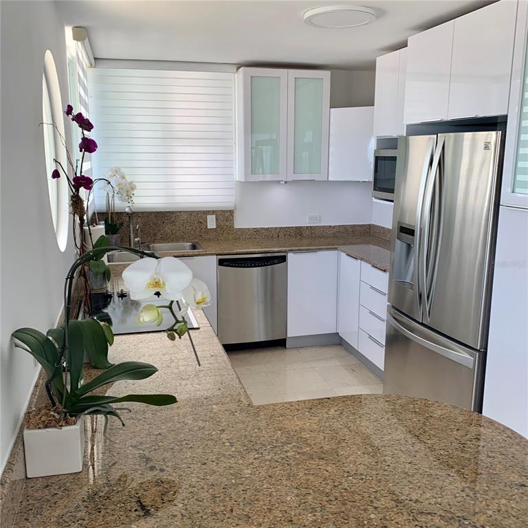 A kitchen features white cabinets, stainless steel appliances, and speckled granite countertops — Regatta 996 ASHFORD AVE UNIT 6, SAN JUAN, PR