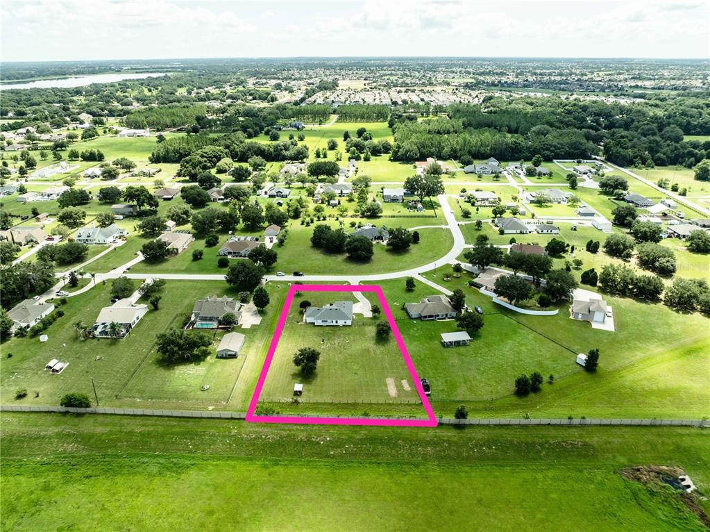 An aerial view shows a single-story house on a large, fenced-in residential lot — 9170 COUNTY ROAD 128D ROAD, WILDWOOD, FL