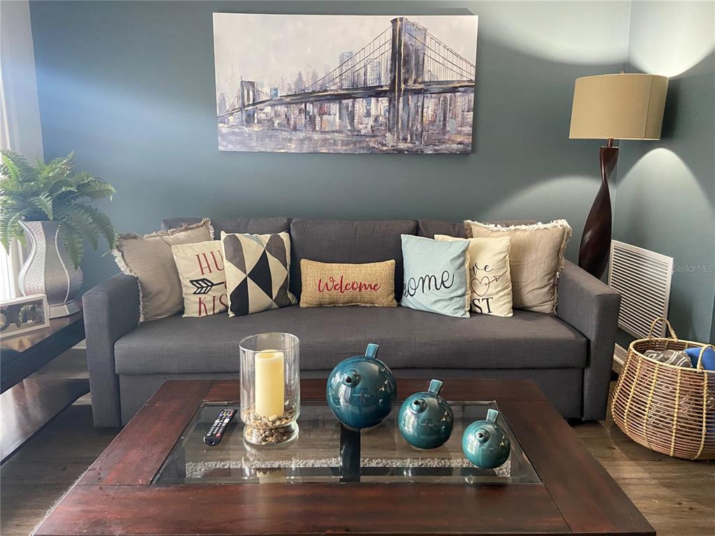 A living room features a gray sofa with decorative pillows, a coffee table, and wall art — 1222 VILLA LANE UNIT 136, APOPKA, FL