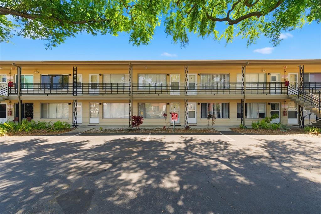 A two-story apartment building exterior with a parking lot and metal balcony railings — 1257 DREW STREET UNIT 14, CLEARWATER, FL