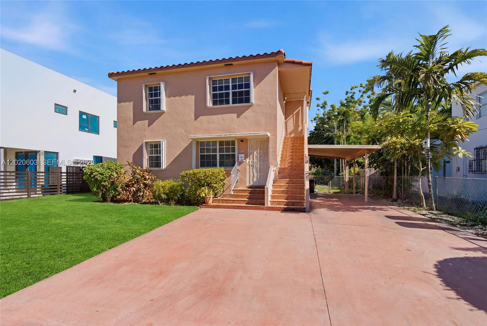 A two-story peach-colored house features an exterior staircase, a carport, and a concrete driveway — 3750 SW 27th St, Miami FL 33134, MIAMI, FL