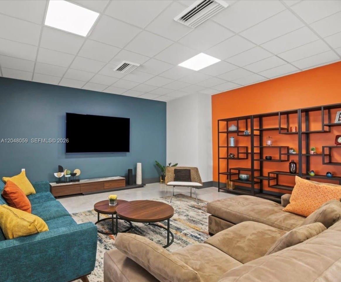 A living room features a blue accent wall with a television and an orange wall — 3140 S Ocean Dr # 1003, Hallandale Beach FL 33009, HALLANDALE BEACH, FL