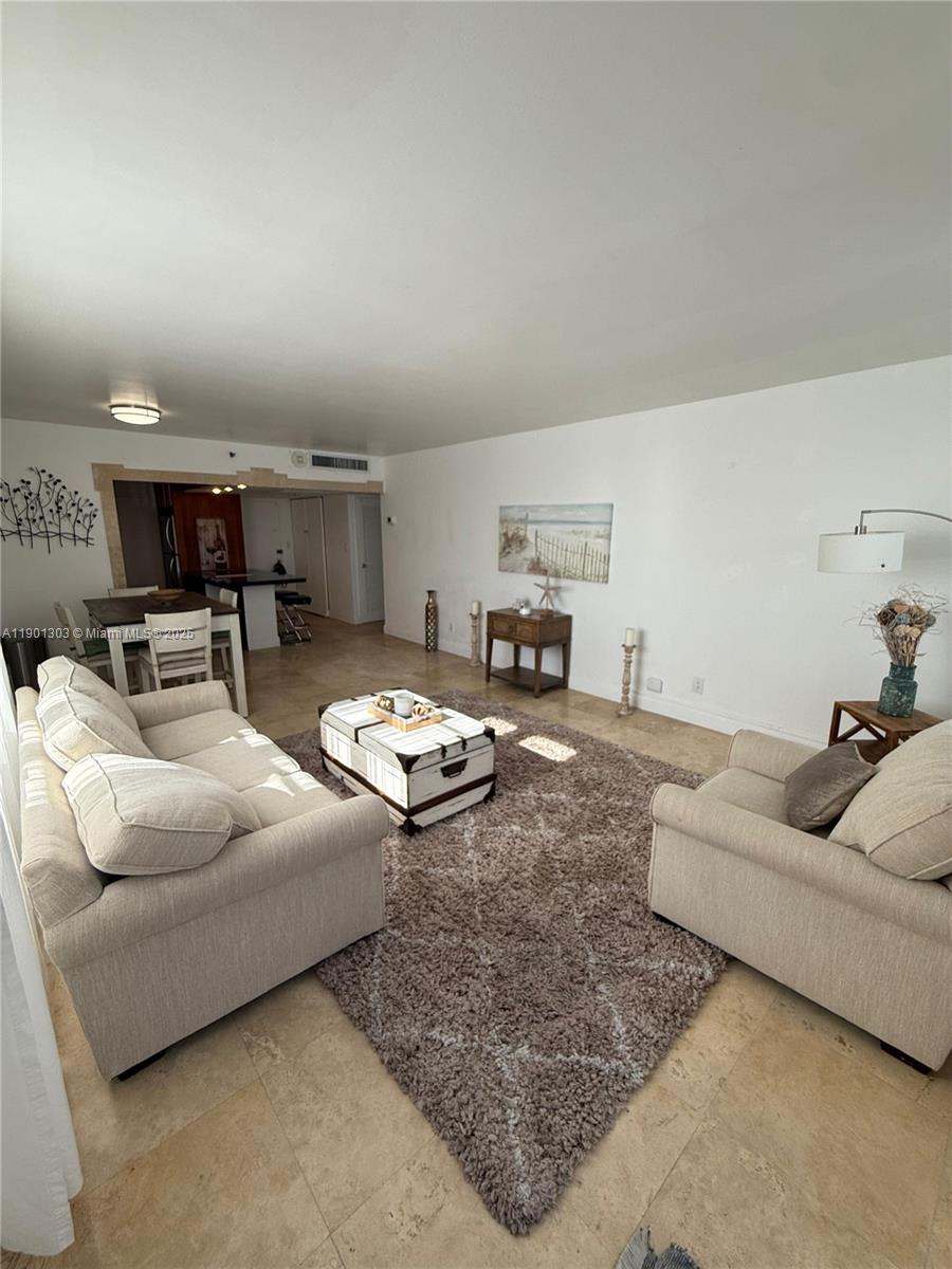 A living room features beige sofas, a textured rug, and an adjacent dining area — 100 Lincoln Rd # 1111, Miami Beach FL 33139, MIAMI BEACH, FL