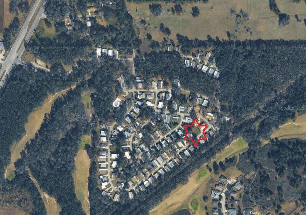 An aerial view of a residential neighborhood with a red star marking a vacant lot — KINGSWOOD CIRCLE, BROOKSVILLE, FL