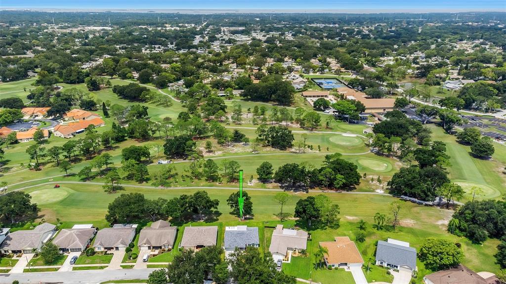 An aerial view shows a suburban neighborhood with houses bordering a golf course — 1308 GILLESPIE DRIVE, PALM HARBOR, FL